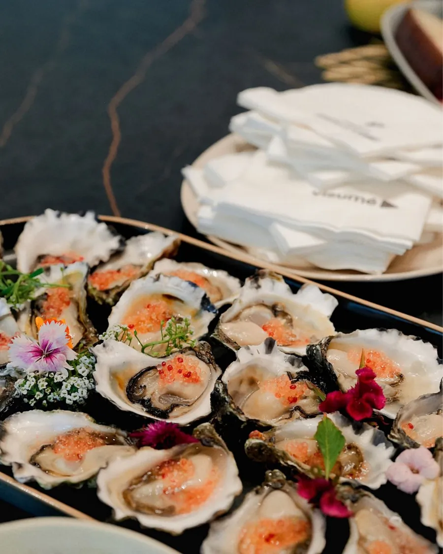 Oysters dressed with edible flowers on a stone platter
