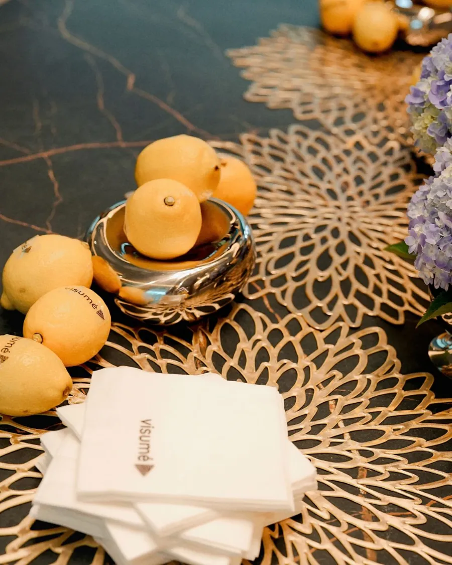 Lemons and branded napkins on a gold-patterned table setting