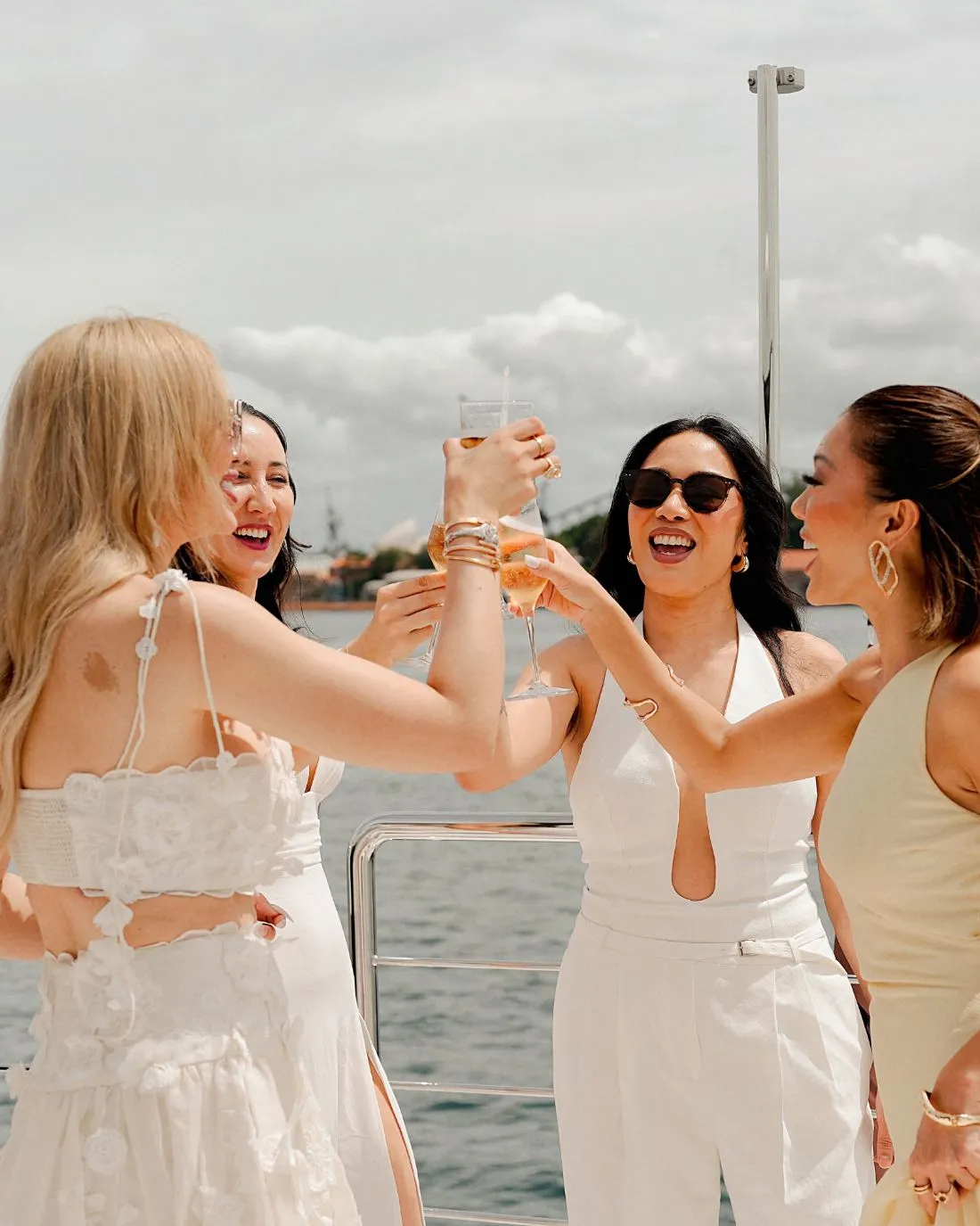 Guests dressed in white raising a toast on the deck of ORRAIA